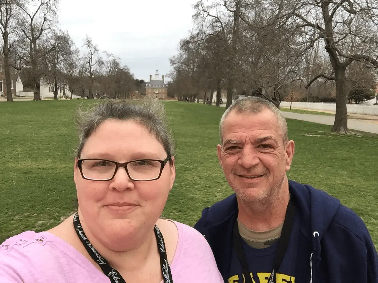 A man and woman standing in front of trees.